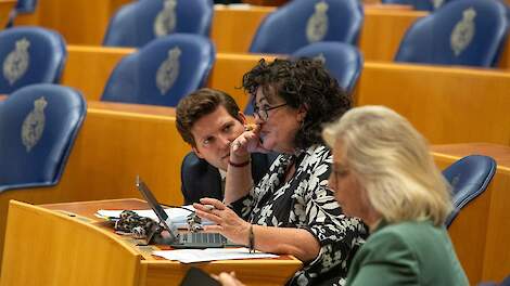 Thom van Campen (VVD) en Caroline van der Plas (BBB) overleggen met elkaar in de Tweede Kamer. Zij maken samen een wetsvoorstel tegen stalbezettingen. Op de voorgrond Jeanet Nijhof-Leeuw (PVV).
