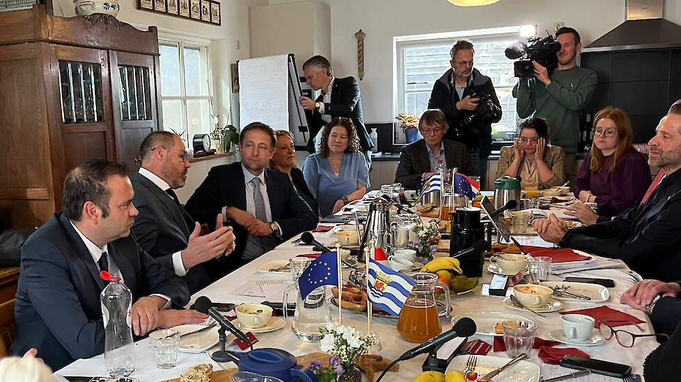 Christophe Hansen (derde van links) luistert aan de keukentafel naar Zeeuws landbouwgedeputeerde Arno Vael.